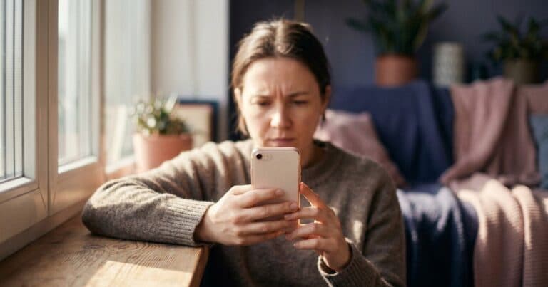 Person schaut mit gerunzelter Stirn auf ihr Smartphone