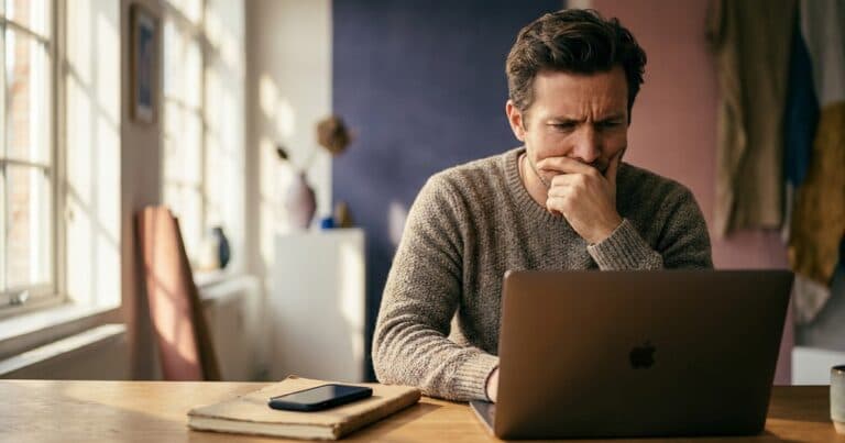 Mann betrachtet nachdenklich Statistiken am Laptop