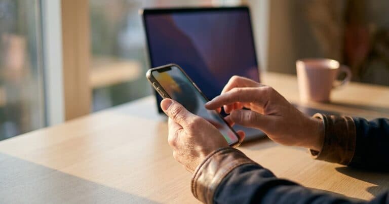 Hände navigieren auf dem Smartphone durch die Einstellungen zum Datenexport