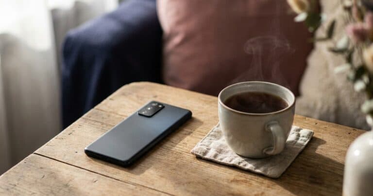 Umgedrehtes Smartphone neben einer Tasse Tee