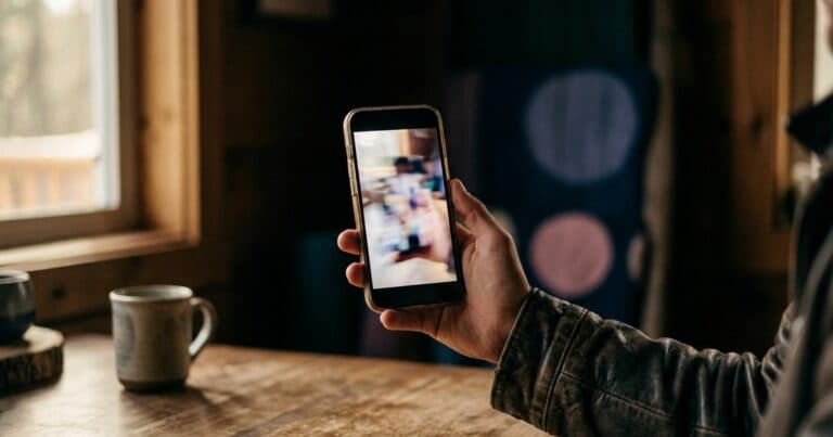 Smartphone hochkant in der Hand mit unscharfem Video